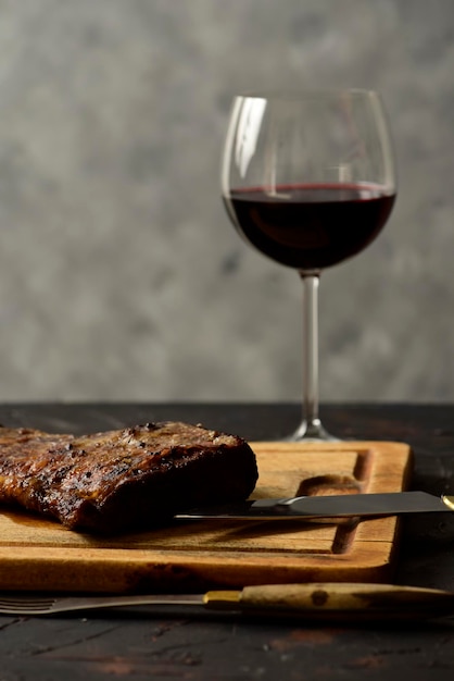 Roasted beef ribs with a glass of red wine presented on the table traditional Argentine cuisine