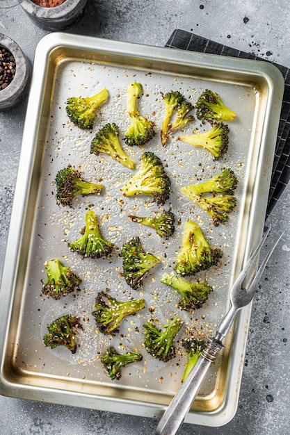 Roasted broccoli cabbage with garlic in baking tray Gray background Top view