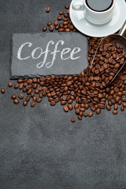 roasted brown coffee beans and stone serving board with chalk handwritten sign