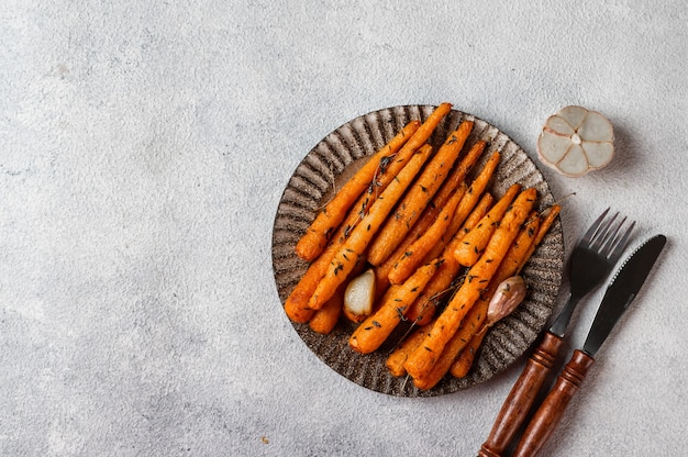 Roasted Carrots Ready to Eat. Glazed carrot with herbs and garlic. Fried carrot on white background. Sauteed vegetables. Comfort food. Christmas garnish