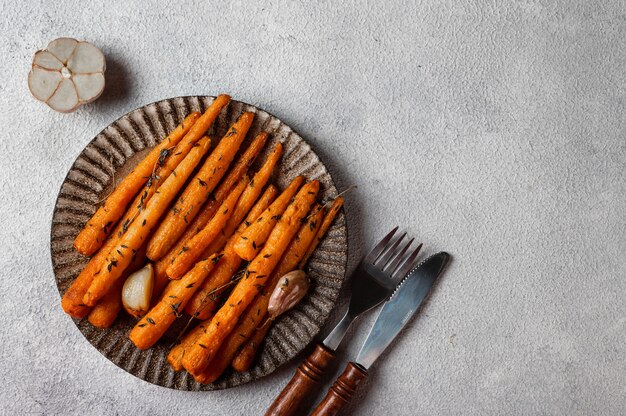 Roasted Carrots Ready to Eat. Glazed carrot with herbs and garlic. Fried carrot on white background. Sauteed vegetables. Comfort food. Christmas garnish