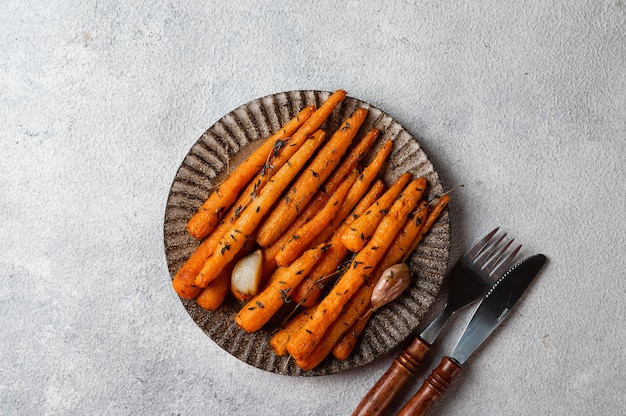 Roasted Carrots Ready to Eat. Glazed carrot with herbs and garlic. Fried carrot on white background. Sauteed vegetables. Comfort food. Christmas garnish