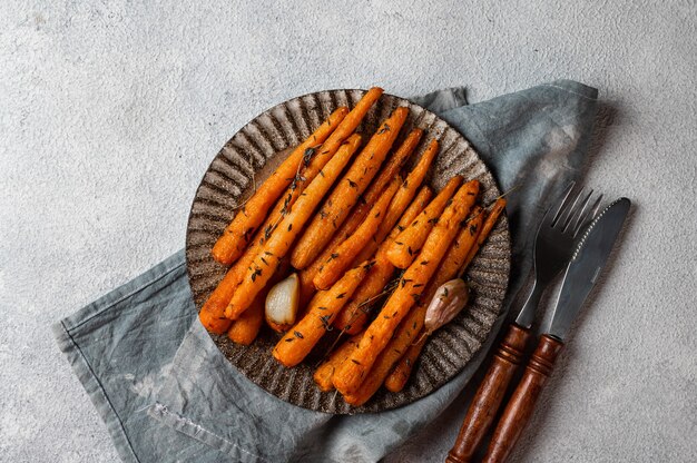 Roasted carrots ready to eat. glazed carrot with herbs and
garlic. fried carrot on white background. sauteed vegetables.
comfort food. christmas garnish