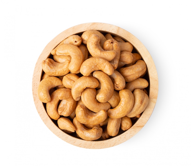 Photo roasted cashew nuts with salt in wood bowl isolated