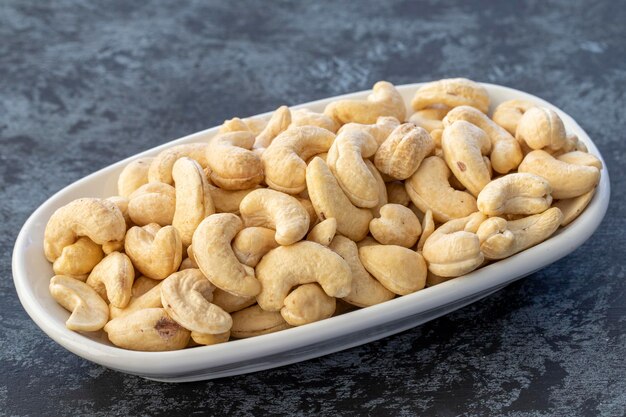 Roasted cashews on plate on dark background