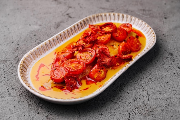 Photo roasted cherry tomatoes on oval plate