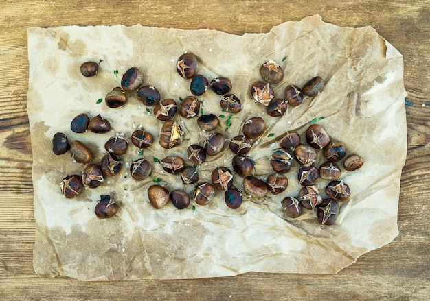 Roasted chestnuts on oily worn craft paper