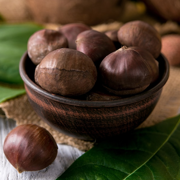 Roasted chestnuts served in chestnut pan on an old table