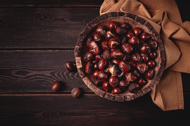 Foto castagne arrostite in un piatto di legno vista superiore casalinga nessuna gente