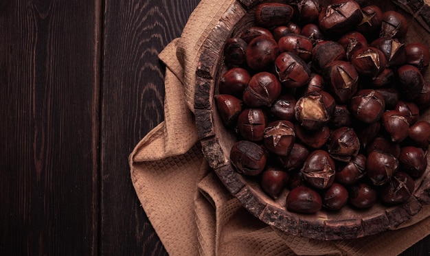 roasted chestnuts in a wooden plate top view homemade no people