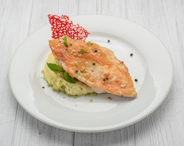 Foto petto di pollo arrosto e purè di patate su un tavolo di legno