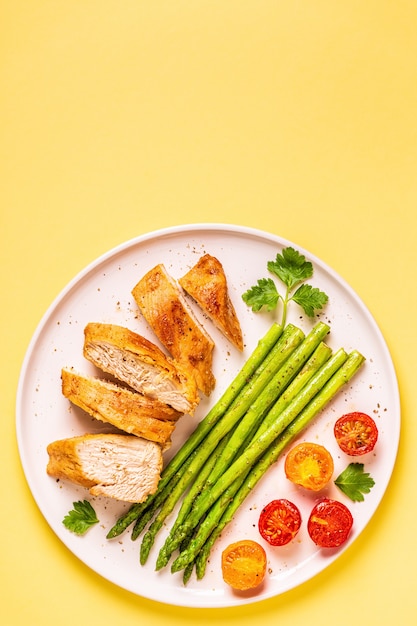 Roasted chicken breast with asparagus and tomatoes