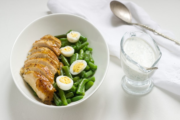 Roasted chicken breasts served with fried egg and boiled green beans.