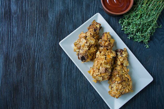 Roasted chicken drumsticks on a plate. 