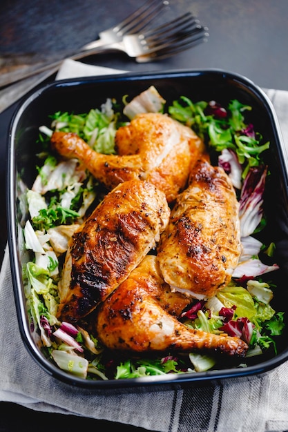 Roasted chicken leg and breast with fresh salad and champignons on a plate