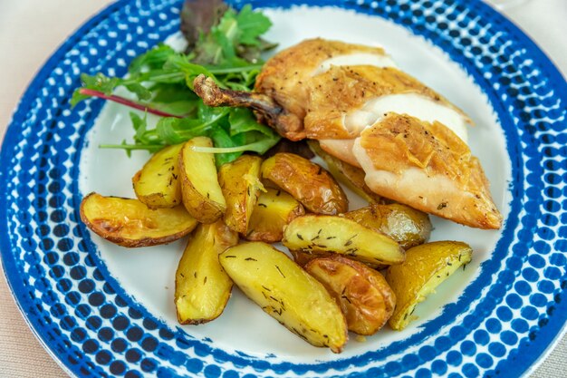 roasted chicken leg with potatoes on a plate in a restaurant