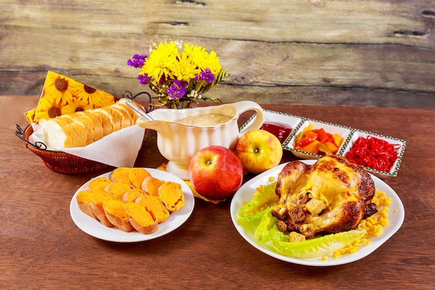 밝은 단풍과 양초로 장식된 칠면조를 곁들인 구운 치킨 추수 감사절 테이블