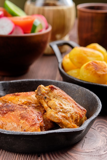 Roasted chicken thighs, fried potato and salad - rustic dinner