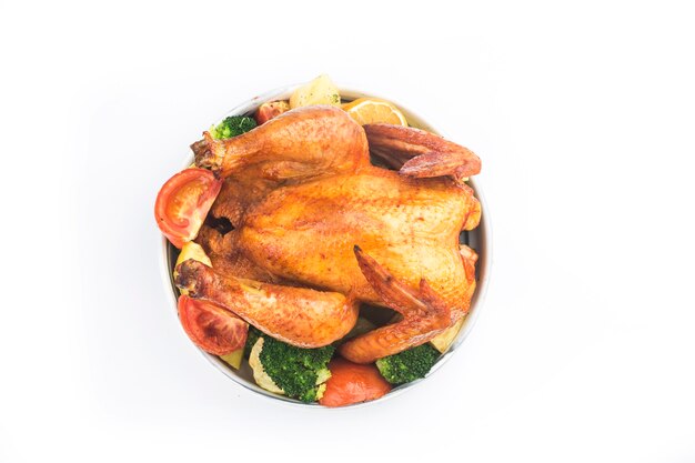 Roasted chicken and vegetables on white table