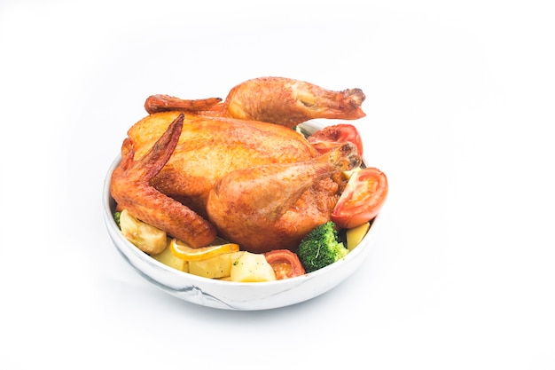 Roasted chicken and vegetables on white table