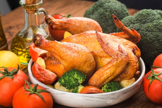 Roasted chicken and vegetables on wooden table