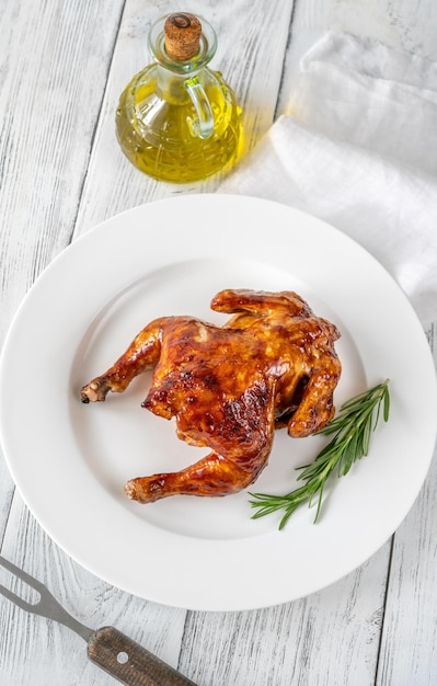 Roasted chicken on the white serving plate