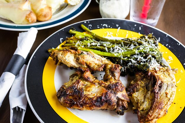 Roasted chicken with broccolini on the plate in Italian restaurant.