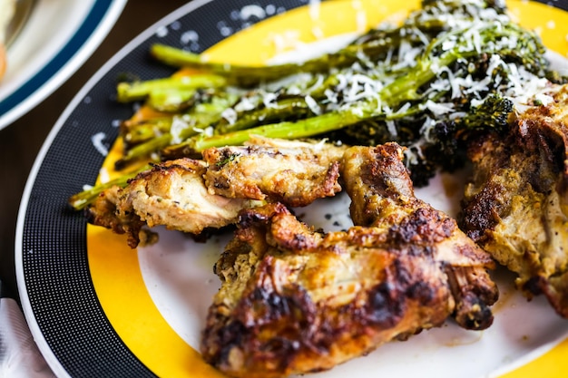 Roasted chicken with broccolini on the plate in Italian restaurant.