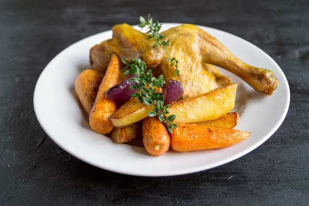 Roasted chicken with carrots and thyme.