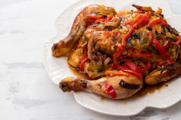 Roasted chicken with herbs and vegetables on white dish