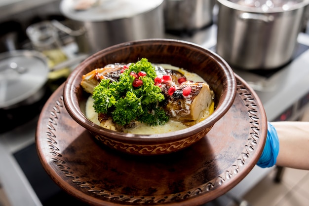 Фото Жареная курица с картофелем и овощами на кухонной плите. кухня