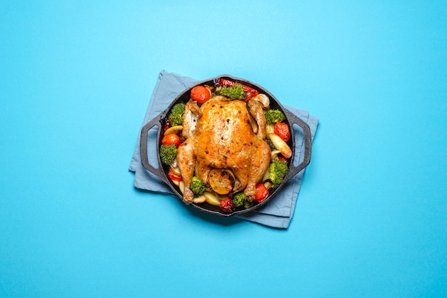 Roasted chicken with vegetables in an iron cast