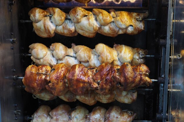 Roasted chickens grilled on the fire of the barbecue