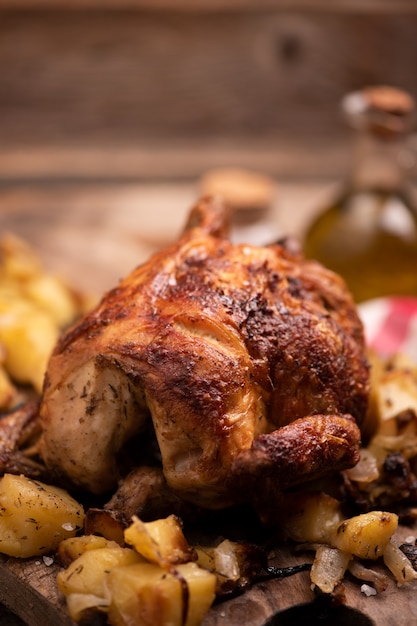 Жареный цыпленок на деревянной доске с чипсами