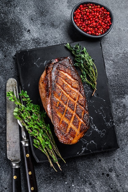 Roasted Christmas duck breast fillet steak. Black background. Top view.