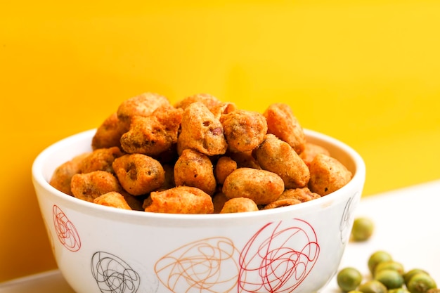 Roasted coated peanuts on white background Delicious snack peanut