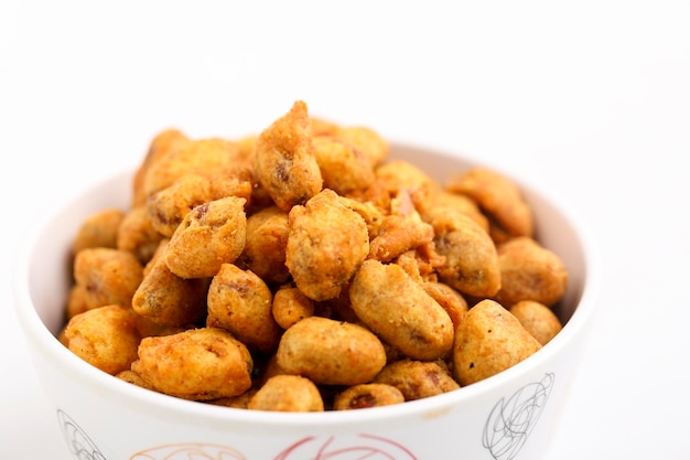 Roasted coated peanuts on white background Delicious snack peanut