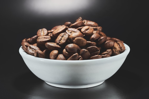 分離されたボウルの焙煎コーヒー豆は、黒い背景のクリッピングパスにクローズアップ