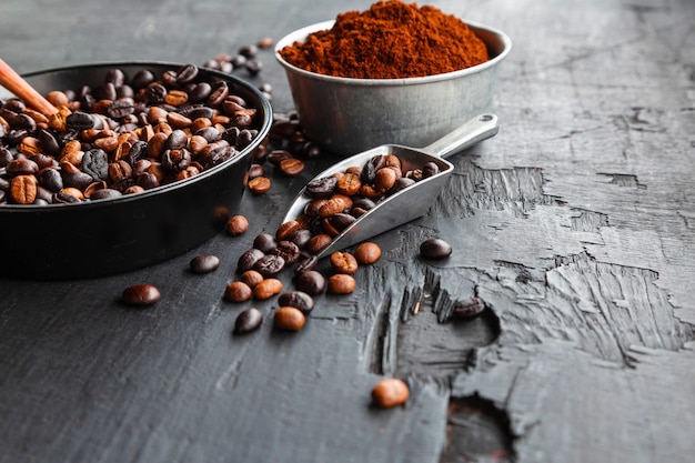 Roasted coffee beans and  coffee powder on black wooden table