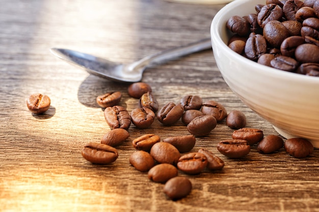 roasted coffee beans in cup on wood table                  