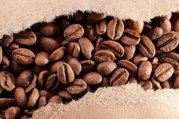 Roasted coffee beans decorated with kraft paper closeup creative background