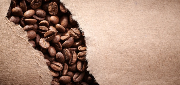 Roasted coffee beans decorated with kraft paper closeup creative background