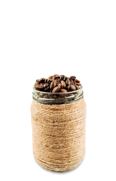 Жареные кофейные зерна в стеклянной банке, цельные кофейные зерна в коричневой банке. Изолировать. Скопируйте пространство.