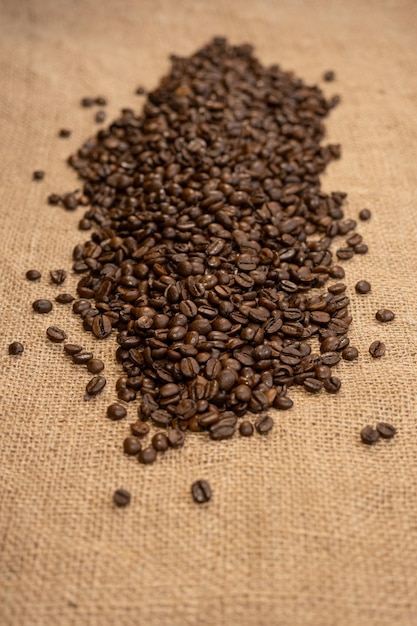 テキスト用の空きスペースと黄麻布の背景に分離された焙煎コーヒー豆
