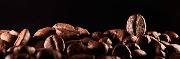 Roasted coffee beans isolated close up on black background clipping path