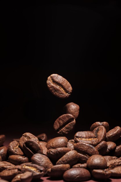 Жареные кофейные зерна изолированы крупным планом на черном фоне.