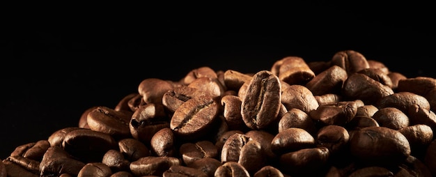 Roasted coffee beans isolated close up on black background clipping path