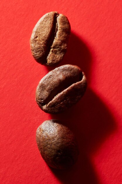 Roasted coffee beans isolated close up on red background clipping path