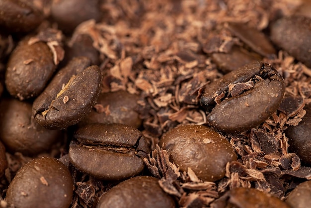 Жареные кофейные зерна лежат вместе с шоколадом, раскрошенным на мелкие кусочки, ароматный кофе вместе с шоколадной крошкой.