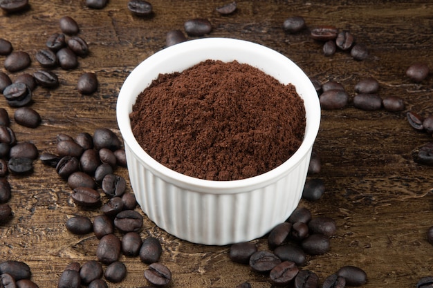 Roasted coffee beans in powder in a white bowl